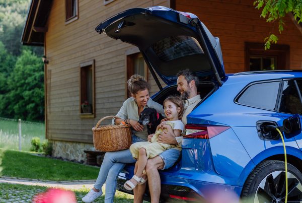 familia feliz con coche eléctrico asegurado seguro de autos confianza protección V2G2