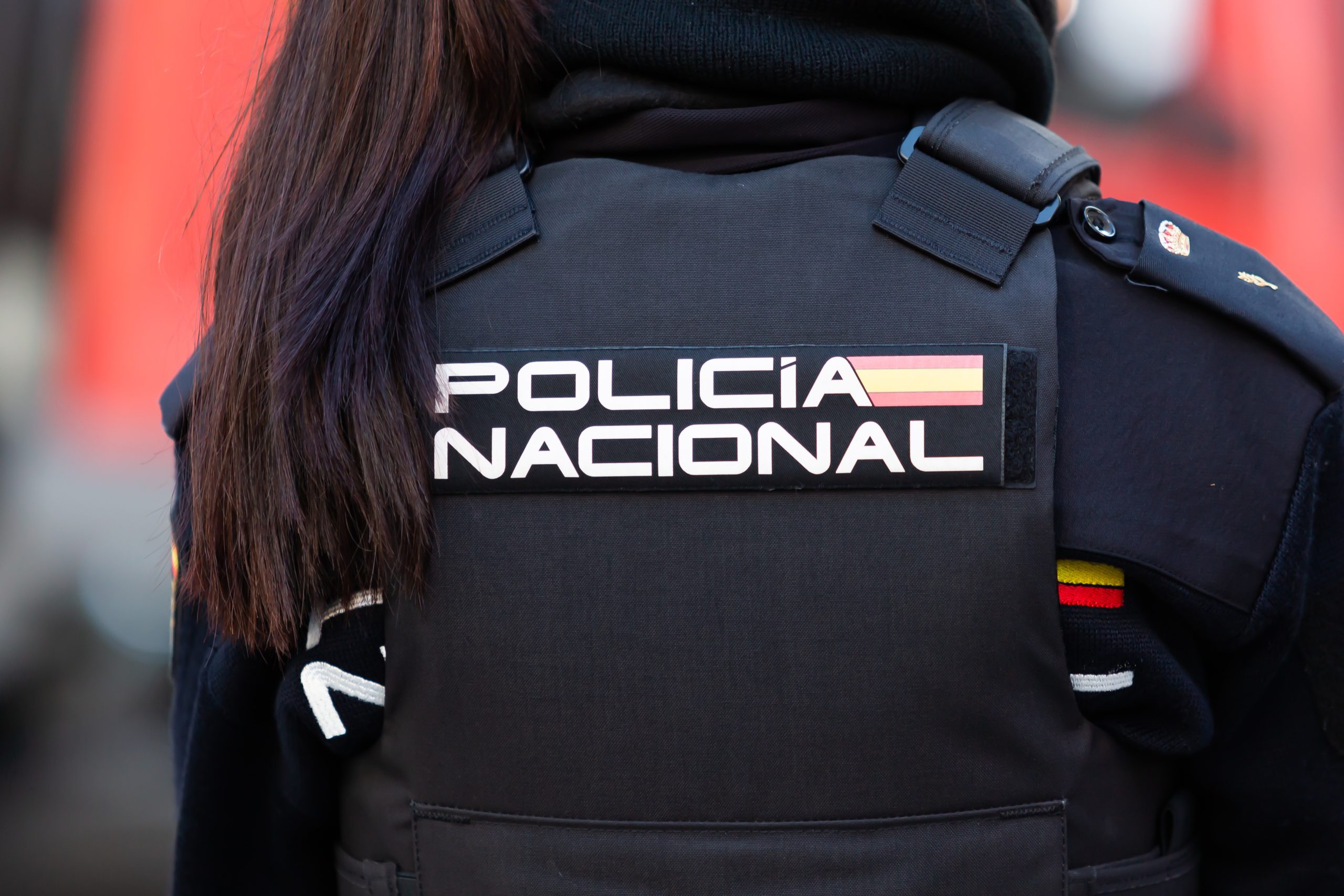 agente de la Policía Nacional de España con uniforme y chaleco antibalas, seguros de vida y accidentes colectivos
