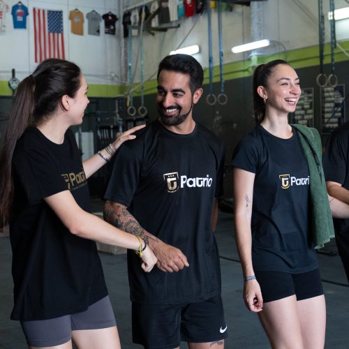 Jóvenes entrenando y sonriendo en un gimnasio, con camisetas de la academia Patrio.