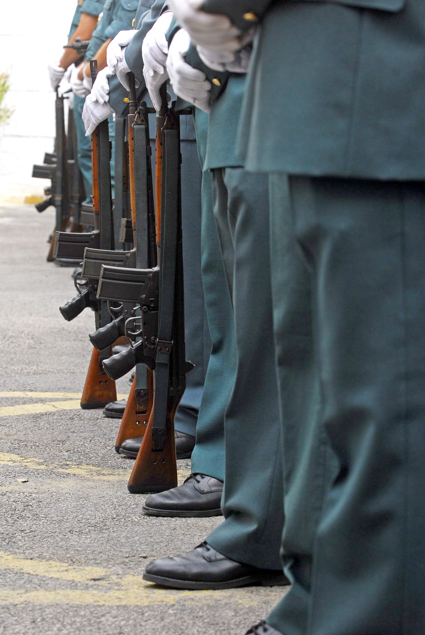 Guardias civiles en formación con uniforme de gala y fusiles reglamentarios.