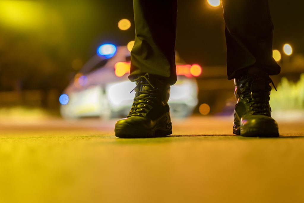 Policía en servicio nocturno junto a vehículo patrulla — seguro de vida y accidentes colectivos Vera2